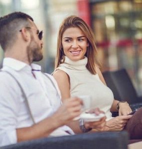 attracting women man and woman sitting and talking, creating rapport and an emotional connection