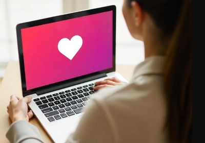 meet people online header image woman looking at dating app on laptop